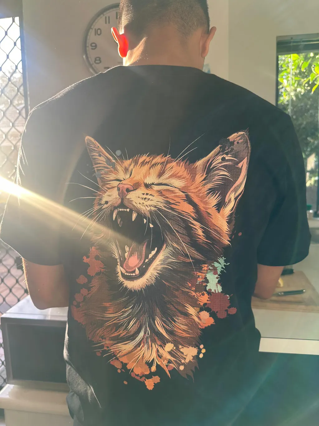 Angel Karki wearing the Unbothered Yawn ginger cat tee from CritterFit Co
