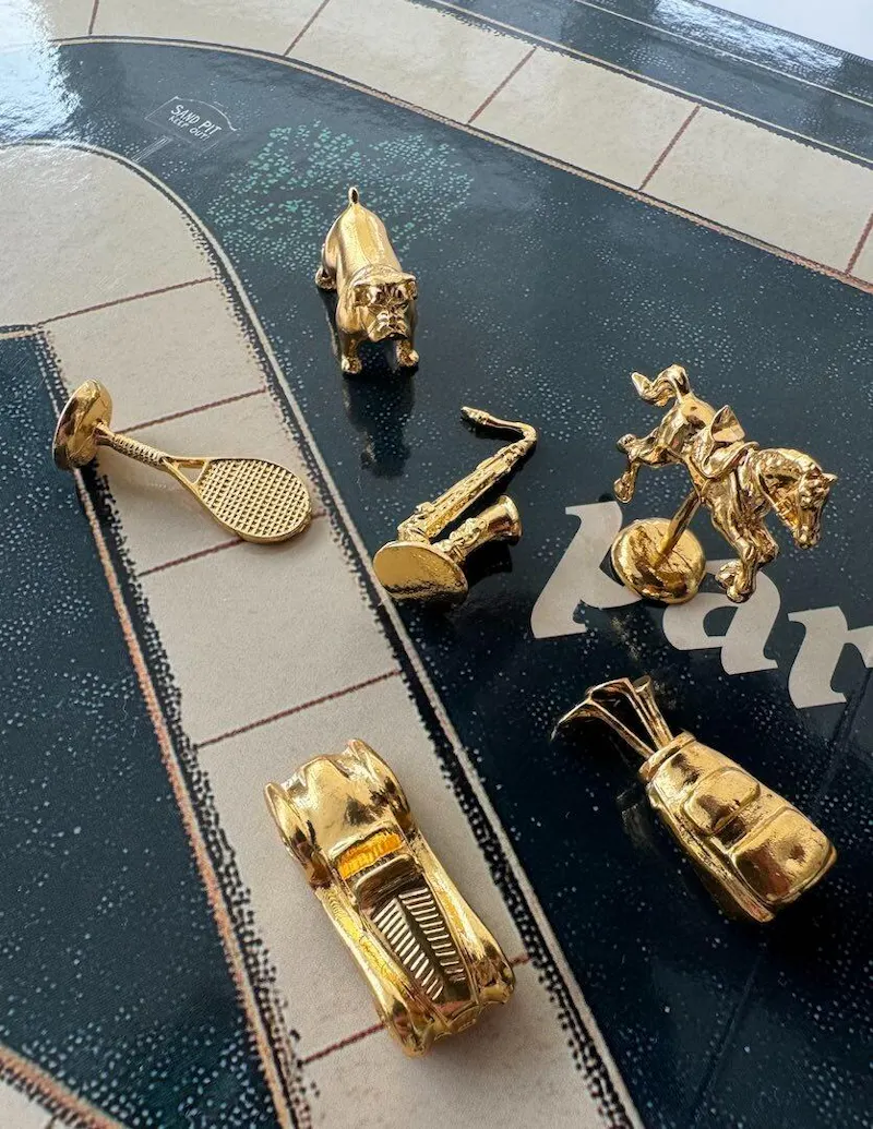 Customer photo — gold metal Parlay player pawns on the board