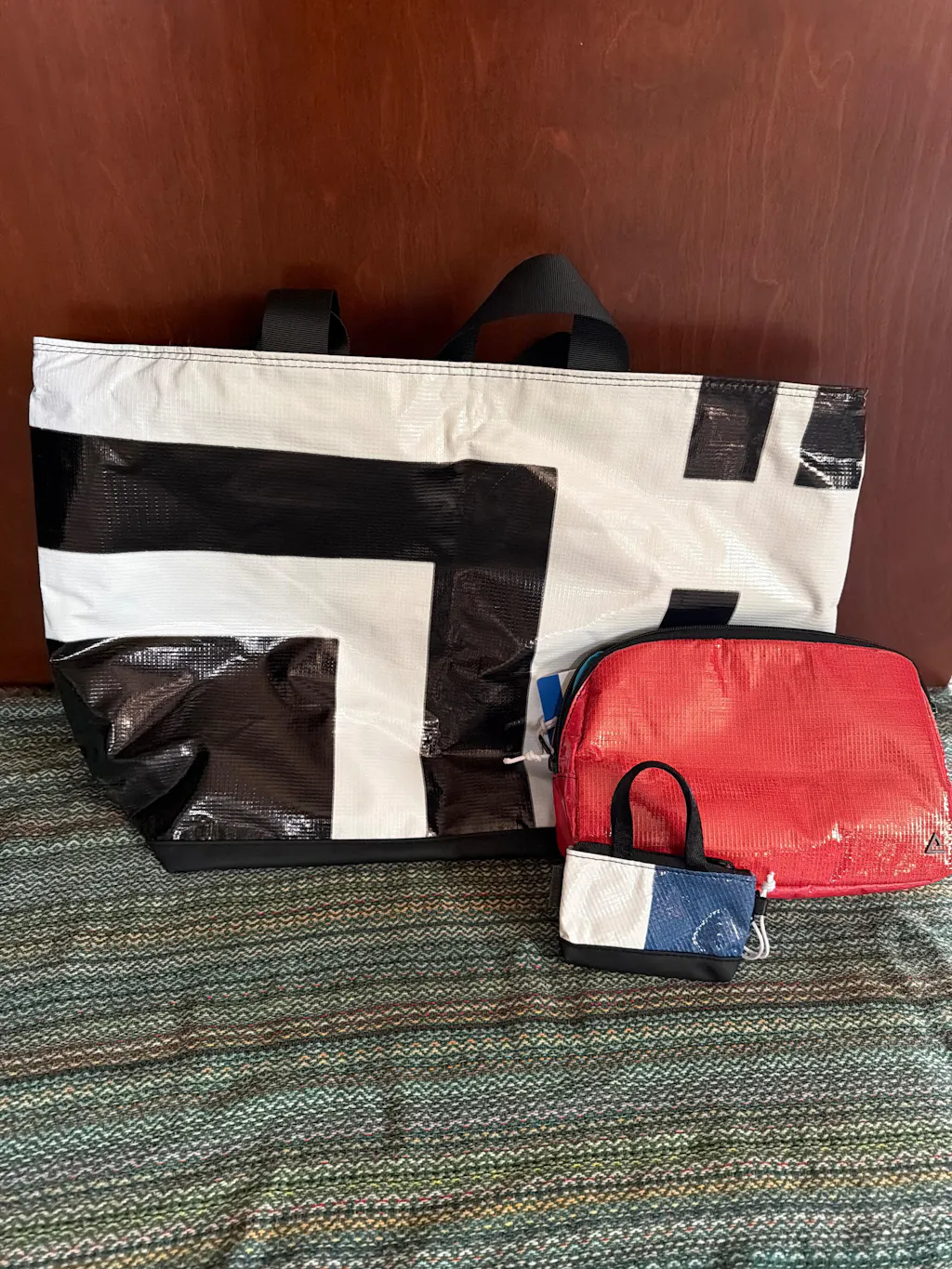 A black and white Blake tote with a red sling and a mini keychain bag, a full Rareform set