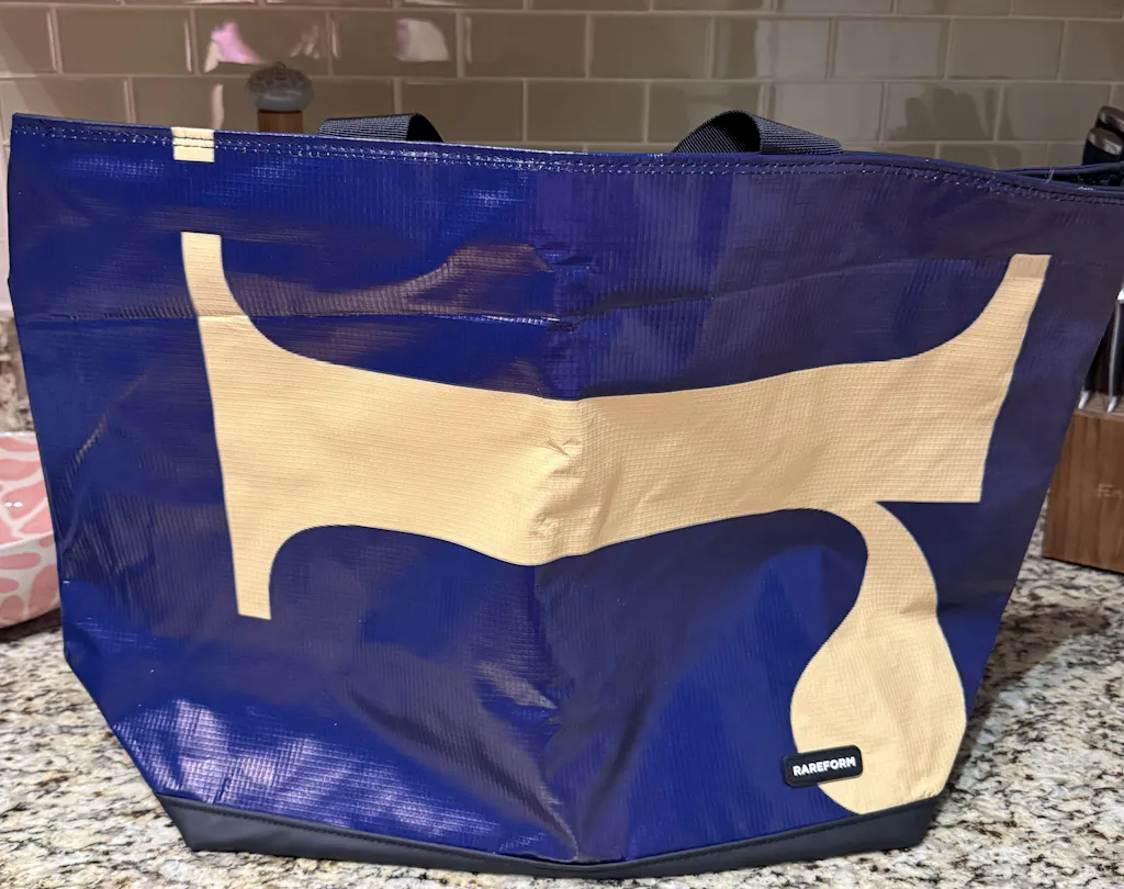 Blue and cream billboard tote with a large R initial, on a kitchen counter