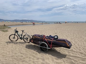 reacha bike trailer on the beach with windsurfing equipment