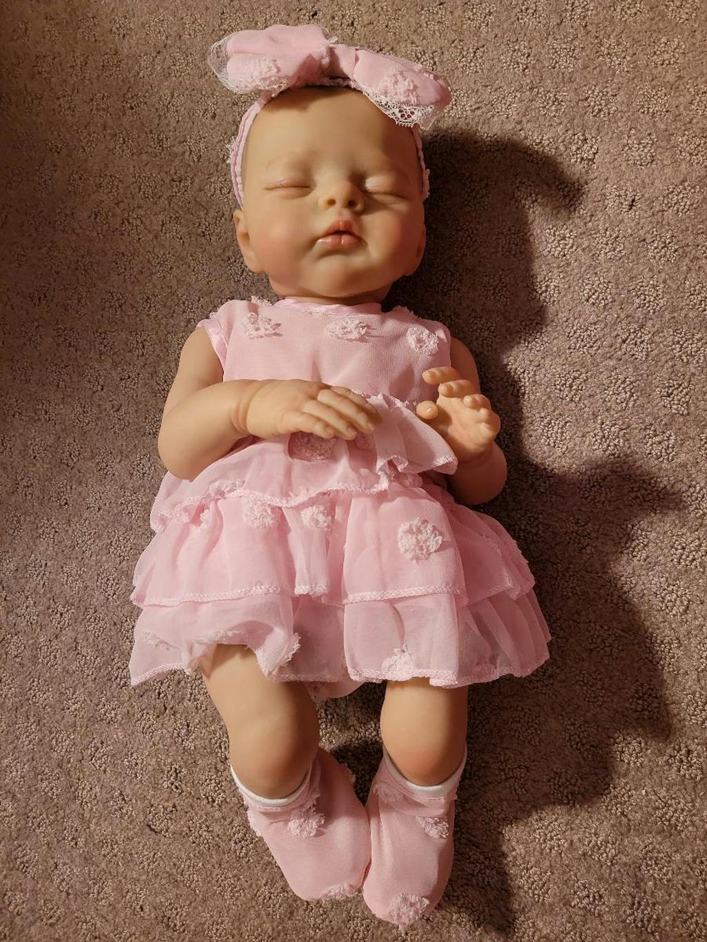 Bambola reborn Irys da 48 cm con corpo morbido e vestito rosa