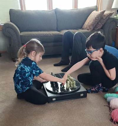Round black and green onyx marble chess set in a customer's living room